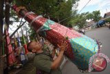 Calon pembeli melihat terompet jumbo yang dijual pedagang di Jl Ganting, Padang, Sumatera Barat, Rabu (30/12). Terompet jumbo setinggi 2,5 meter dengan berat tiga kilogram dijual menjelang malam pergantian tahun dengan harga Rp325 ribu. ANTARA FOTO/Iggoy el Fitra/wdy/15