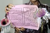 Warga memperlihatkan terompet dari lembaran kertas Alquran hasil sitaan di Lhokseumawe, Aceh. Kamis (31/12) dini hari. Ratusan terompet tahun baru yang dibuat menggunakan lembaran Alquran disita petugas keamanan setempat karena dinilai merupakan bentuk penodaan terhadap agama. ANTARA FOTO/Rahmad/kye/15