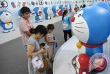 Pengunjung mengamati diorama tokoh animasi robot kucing Doraemon pada pameran 'Doraemon 100 Secret Gadget Expo' di Grand City Surabaya, Jawa Timur, Minggu (3/1). Pameran yang digelar hingga 14 Februari 2016 tersebut menjadi daya tarik tersendiri bagi pengunjung dari berbagai daerah untuk memanfaatkan liburan sekolah dan tahun baru. Antara Jatim/M Risyal Hidayat/zk/16