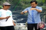 Wali Kota Bogor, Bima Arya Sugiarto (kanan) mengangkat ikan hasil pancingan di Kolam pemancingan Kompleks Bendung Katulampa, pada Silaturahim dan lomba memancing ikan mengakhiri tahun 2015 dan menyambut tahun 2016 bersama para Pejabat dan Wartawan Kota Bogor, Jawa Barat. (ANTARA FOTO/M.Tohamaksun).