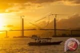 Panorama senja terakhir tahun 2015 di Teluk Ambon dengan latar belakang pembangunan Jembatan Merah Putih, Ambon, Maluku, Kamis (31/12). Jembatan Merah Putih yang merupakan ikon baru di Pulau Ambon, menjadi salah satu lokasi perayaan malam pergantian tahun ditandai dengan pesta kembang api. ANTARA FOTO/Embong Salampessy/aww/15.