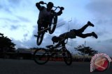 Dua pemuda bermain sepeda BMX di komplek terminal Kota Lhokseumawe, Provinsi Aceh. Selasa (5/1). Mereka terpaksa bermain di lahan yang tidak semestinya karena ketiadaan tempat bermain yang layak. ANTARA FOTO/Rahmad/16.