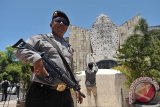 Seorang polisi mengawasi aktifitas wisatawan dan masyarakat di kawasan Monumen Bom Bali, Kuta, Jumat (15/1). Kawasan wisata dan sejumlah obyek vital di Bali diawasi dengan ketat oleh aparat kepolisian pascaledakan bom di Jakarta. FOTO ANTARA/Nyoman Budhiana/i018/2016.