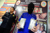 Tersangka kurir pembawa ganja berinisial ZM memperlihatkan barang bukti ganja saat gelar ungkap kasus di Mako Direktorat Reserse Narkoba Polda Kalbar, Rabu (20/1). Ditresnarkoba Polda Kalbar berhasil mengungkap pengiriman narkoba jenis ganja kering asal Aceh seberat 8,9 kilogram yang dilakukan oleh kurir berinisial ZF dan dikendalikan oleh seorang napi penghuni Lembaga Pemasyarakatan Kelas IIA Pontianak berinisial M. ANTARA FOTO/Jessica Helena Wuysang/16
