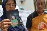 Poniyem (kiri) didampingi suaminya, Sarjono menunjukkan foto anaknya, Rita Krisdianti, Tenaga Kerja Wanita (TKW) yang terancam hukuman mati di Malaysia, saat menggelar aksi penolakan hukuman mati bagi Rita Krisdianti di depan Gedung DPRD Kabupaten Ponorogo, Jawa Timur, Senin (25/1). Rita Kridianti TKW asal Desa Gabel, Kecamatan Kauman Ponorogo saat ini menjalani proses persidangan dalam perkara narkoba dengan ancaman hukuman mati, dan pihak keluarga mendesak pemerintah untuk membebaskan Rita dari hukuman karena menurut mereka, Rita sebagai korban dalam perkara tersebut. Antara Jatim/Foto/Siswowidodo/16