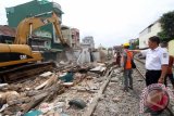 Humas PT KAI Divre I Sumatera Utara Rapino Situmorang (kanan) meninjau perobohan rumah didekat lahan pelintasan kereta api di Jalan Salak Medan, Sumatera Utara, Rabu (27/1). PT KAI melakukan pelebaran untuk pembangunan jalur ganda (double track) sepanjang 28,8 KM kereta api Bandara Kualanamu yang ditargetkan siap pada Juli 2016 mendatang. ANTARA SUMUT/Septianda Perdana/16 