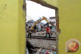 Pekerja PT KAI merobohkan bangunan rumah didekat lahan pelintasan kereta api dengan alat berat di Jalan Salak Medan, Sumatera Utara, Rabu (27/1). PT KAI melakukan pelebaran untuk pembangunan jalur ganda (double track) sepanjang 28,8 KM kereta api Bandara Kualanamu yang ditargetkan siap pada Juli 2016 mendatang. ANTARA SUMUT/Septianda Perdana