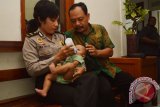 Polwan menggendong bayi, Abi (6 bulan) yang berhasil diselamatkan dari tangan penculik di Mapolres Madiun, Jawa Timur, Jumat (29/1). Seorang pembantu rumah tangga, Intan bersama pacarnya, Manalu menculik bayi tersebut dari ibunya, Sri Nurobi warga Dolopo, Kabupaten Madiun dan disembunyikan di Sidoarjo, Jawa Timur selama empat hari sebelum akhirnya ditangkap polisi. Antara Jatim/Foto/Siswowidodo/zk/16