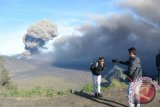 Seorang pengunjung berfoto dengan latar belakang Gunung Bromo erupsi di Puncak Bukit 29, Desa Argosari, Senduro, Lumajang, Jawa Timur, Sabtu (30/1). Paskah penutupan pendakian ke Gunung Bromo dan lautan pasir dengan radius aman 2,5 Km, sejumlah pengunjung banyak mengunjungi Puncak Bukit 29 dengan ketinggian 2900 meter diatas permukaan air laut (mdpl) yang bisa melihat erupsi Gunung Bromo dan lautan pasir dari atas. Antara Jatim/Seno/16.