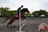 Seorang pelatih mengendalikan kuda melompati rintangan di arena latihan Trotter Equestrian Center, kawasan Wisata Pantai ria Kenjeran, Surabaya. Kamis (4/2). Tempat tersebut merupakan salah satu tempat belajar berkuda di Surabaya dan berdiri sejak 1982. Antara Jatim/Abdullah Rifai/16