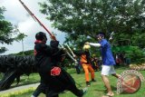 Anggota komunitas Cosplay HCL Jombang memperagakan aksi di ruang terbuka hijau (RTH) Keplaksari, Jombang, Jawa Timur, Senin (8/2). Aksi tersebut selain untuk memberi hiburan warga yang sedang mengisi liburan di taman itu juga memperkenalkan keberadaan komunitas Cosplay di Jombang. Antara Jatim/Syaiful Arif/zk/16