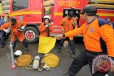 Petugas berpacu mengenakan perlengkapan pemadam kebakaran saat lomba ketangkasan pemadaman api dan penyelamatan korban di Surabaya, Jawa Timur, Rabu (10/2). Kegiatan yang mengutamakan ketangkasan, ketrampilan dan kerjasama tim serta diikuti oleh 26 tim dari seluruh UPTD Pemadam Kebakaran di Dinas Kebakaran Kota Surabaya tersebut dalam rangka menyambut HUT Ke-97 Pemadam Kebakaran (PMK). Antara Jatim/Didik Suhartono/zk/16