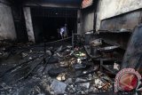 Warga menyaksikan sisa-sisa barang yang terbakar akibat ledakan gas di sebuah rumah makan di Jalan Seksama Medan, Sumatera Utara, Kamis (11/2). Akibat ledakan yang diduga berasal dari tabung gas elpiji  itu mengakibatkan dua orang luka bakar. ANTARA SUMUT/Septianda Perdana/16