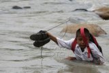 Seorang anak sekolah Madrasah Ibtidaiyah berusaha menyeberangi sungai di Desa Mangepong, Kabupaten Jeneponto, Sulawesi Selatan, Rabu (10/2). Siswa daerah tersebut banyak meliburkan diri karena curah hujan yang tinggi menyebabkan air sungai meluap. (Foto Jojon)