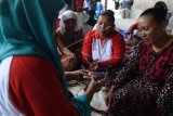 Anggota Yayasan Sekar Mandiri bekerjasama dengan PT Pertamina EP mendampingi istri-istri nelayan membuat kerajinan tangan dari limbah bungkus kopi di daerah Rengasdengklok, Karawang, Jawa Barat, Kamis (11/2). Program tanggung jawab sosial PT Pertamina EP yang bernama program Bank Sampah tersebut bertujuan memberdayakan warga agar lebih produktif sehingga dapat membantu perekonomian keluarga sekaligus mengurangi sampah di lingkungan mereka. ( Foto Hafidz Mubarak A)