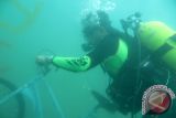 Penyelam dari Komunitas Penyelam Surabaya Pelestari Laut menenggelamkan rumpon ikan di Pantai Pasir Putih, Situbondo, Jawa Timur, Sabtu (13/2). Sebanyak tiga puluh orang penyelam dari Semen Gresik Diving Club dan Society-82 Diving Club Surabaya menenggelamkan sejumlah rumpon ikan, berupa becak, sepeda onthel, dan balok beton untuk melestarikan lingkungan perairan laut yang merupakan tempat tinggal ikan. Antara Jatim/Hendrik/sen/16.