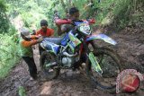 Sejumlah warga menarik motor trail peserta TRIAT 2 Adventure yang terjebak sungai berlumpur di jalur tengkorak, Wonorejo, Tulungagung, Jawa Timur, Minggu (14/2). Olahraga motor sport yang mengandalkan ketahanan fisik serta kelihaian berkendara di medan sulit tersebut diiikuti lebih dari 1.500 peserta dari berbagai daerah se-Jawa dan Bali sekaligus sebagai ajang promosi wisata daerah. Antara Jatim/Destyan Sujarwoko/zk/16