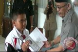Pendiri sekaligus Penanggung Jawab Baldatun Center, Ade Dasep Zainal Abidin menyerahkan wakaf Al-Quran untuk pelajar berprestasi dari SDN 03 Nagrak Utara, Kabupaten Sukabumi. (Foto Antara/ Aditya A Rohman).

