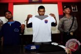 Tersangka polisi gadungan, Te (tengah) didampingi rekannya Le (kiri), memperlihatkan baju provost yang dimilikinya saat rilis kasus di Mapolsek Pontianak Selatan, Kalbar, Senin (15/2). Te yang dibekuk bersama rekannya, Le karena menganiaya juru parkir di Jalan Perdana Pontianak, Rudi Alfian pada Sabtu (13/2) malam dan mengaku bahwa dirinya anggota Provost tersebut, mengaku baru sekitar dua bulan memiliki atribut Provost Polri yang dibelinya karena terobsesi ingin menjadi petugas kepolisian. (Foto Jessica Helena Wuysang).