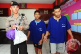 Tersangka polisi gadungan, Te (kanan) didampingi rekannya Le (tengah), berjalan bersama usai rilis kasus di Mapolsek Pontianak Selatan, Kalbar, Senin (15/2). Te yang dibekuk bersama rekannya, Le karena menganiaya juru parkir di Jalan Perdana Pontianak, Rudi Alfian pada Sabtu (13/2) malam dan mengaku bahwa dirinya anggota Provost tersebut, mengaku baru sekitar dua bulan memiliki atribut Provost Polri yang dibelinya karena terobsesi ingin menjadi petugas kepolisian. (Foto Jessica Helena Wuysang).