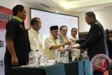 Ketua Sidang Djumaderi Masrun memberikan salinan keputusan Musyawarah Olahraga Provinsi Luar Biasa 2016 kepada Bambang Heri Purnomo yang ditetapkan secara aklamasi sebagai Ketua Umum KONI Kalsel Pengganti Antar Waktu periode 2013-2017 di Ballroom Rattan Inn Banjarmasin, Sabtu (20/2). Foto Antaranews Kalsel/Herry Murdy Hermawan