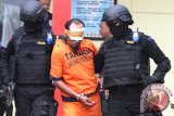 Anggota Detasemen Khusus (Densus) 88 Anti Teror menggiring satu dari enam terduga kasus teroris menuju mobil untuk dipindahkan di Markas Detasemen B Pelopor Satuan Brimob Polda Jatim, Ampeldento, Malang, Jawa Timur, Minggu (21/2). Sebelumnya, enam orang terduga teroris yang disinyalir terlibat dalam teror bom Tamrin-Jakarta tersebut ditangkap dalam penyergapan di sebuah rumah di kawasan Karangploso-Malang. Antara Jatim/Ari Bowo Sucipto/zk/16