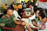 Seorang anggota TNI bersama sejumlah warga memeriksakan kesehatanya pada kegiatan bakti sosial kesehatan di Taman Blambangan, Banyuwangi, Jawa Timur, Kamis (25/2). kegiatan cek kesehatan gratis tersebut, melibatkan 33 dokter umum dan 6 dokter gigi, yang bertujuan untuk meningkatkan pelayanan kesehatan pada masyarakat. Antara Jatim/Budi Candra Setya/zk/16.