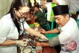 Wakil Bupati Banyuwangi Yusuf Widiyatmoko (kanan) memeriksakan kesehatanya pada kegiatan bakti sosial kesehatan di Taman Blambangan, Banyuwangi, Jawa Timur, Kamis (25/2). kegiatan cek kesehatan gratis tersebut, melibatkan 33 dokter umum dan 6 dokter gigi, yang bertujuan untuk meningkatkan pelayanan kesehatan pada masyarakat. Antara Jatim/Budi Candra Setya/zk/16.