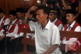 Saksi Tosan (tengah) mengikuti sidang kasus kekerasan tambang pasir Lumajang di Pengadilan Negeri (PN) Surabaya, Jawa Timur, Kamis (25/2). Sebanyak 35 terdakwa kasus kekerasan tambang pasir Lumajang yang mengakibatkan tewas nya aktifis lingkungan hidup Salim Kancil dan peanganiayaan terhadap Tosan menjalani sidang dengan agenda mendengarkan keterangan saksi. Antara Jatim/M Risyal Hidayat/zk/16