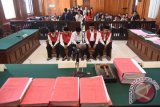 Kepala Desa Selo Awar-Awar Lumajang, Hariyono (kanan) dan sejumlah terdakwa lainnya mengikuti sidang kasus kekerasan tambang pasir Lumajang di Pengadilan Negeri (PN) Surabaya, Jawa Timur, Kamis (25/2). Sebanyak 35 terdakwa kasus kekerasan tambang pasir Lumajang yang mengakibatkan tewas nya aktifis lingkungan hidup Salim Kancil dan peanganiayaan terhadap Tosan menjalani sidang dengan agenda mendengarkan keterangan saksi. Antara Jatim/M Risyal Hidayat/zk/16