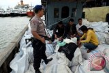 Personel Dit Polair Polda Sumatera Utara, berjaga dekat empat orang ABK yang mengangkut pakaian bekas, di Belawan, Medan, Senin (29/2). Pihak Dit Polair berhasil menangkap satu orang nahkoda dan empat orang ABK KM Evan yang menyelundupkan 180 bal pakaian bekas asal Malaysia. ANTARA FOTO/Irsan Mulyadi/wdy/16.