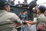 Petugas Satuan Polisi Pamong Praja (Satpol PP) mengamankan sejumlah anak jalanan dari atas truk saat razia Gelandangan dan Pengemis (Gepeng) di Kota Kediri, Jawa Timur, Rabu (2/3). Razia yang bertujuan meminimalisir aksi premanisme jalanan tersebut berhasil mengamankan sedikitnya 9 anak jalanan (anak Punk) yang selanjutnya dikirim ke Dinas Sosial dan Tenaga Kerja untuk dibina. Antara Jatim/Prasetia Fauzani/zk/16