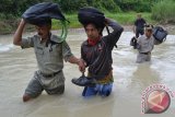 Sejumlah guru SDN Pojok Klitih III melewati sungai saat berangkat mengajar di Desa Pojok Klitih, Plandaan, Jombang, Jawa Timur, Selasa (1/3). Sembilan guru, dua diantaranya guru tidak tetap (GTT) kategori 2 yang bertugas di desa terpencil di Kabupaten Jombang selama 12 tahun, setiap hari harus menempuh perjalanan 4 Km selama 1,5 jam dengan berjalan kaki saat musim hujan melewati tiga sungai untuk sampai ke SDN Pojok Klitih III di Dusun Nampu. (Foto yaiful Arif)