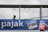 Seorang pejalan kaki melintasi papan sosialisasi pembayaran pajak secara online di Jakarta, Selasa (1/3). Direktorat Jenderal Pajak membuat peta zona potensial pajak untuk mencapai target penerimaan pajak sebesar Rp1.360,1 triliun pada 2016. (Foto Wahyu Putro A/ama)