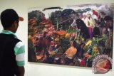 Pengunjung mengamati repro lukisan yang dipamerkan dalam pameran Jejak Lukisan Palsu Indonesia di Institut Seni Indonesia Denpasar, Bali, Sabtu (5/3). Pameran dan diskusi yang digelar Perkumpulan Pencinta Senirupa Indonesia tersebut bertujuan sebagai media sosialisasi dan edukasi tentang keberadaan lukisan palsu yang sedang mengemuka dalam dunia seni rupa Indonesia. ANTARA FOTO/Fikri Yusuf/wdy/16.