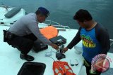 Petugas kepolisian memeriksa barang yang ditemukan oleh tim selam di dalam bangkai kapal Rafelia II di Selat Bali,Banyuwangi, Jawa Timur, Minggu (6/3). Barang-barang seperti radio dan cctv yang ditemukan tersebut, nantinya akan dijadikan bahan pemeriksaan untuk mengetahui penyebab tenggelamnya kMP Rafelia II. Antara Jatim/Budi Candra Setya/zk/16