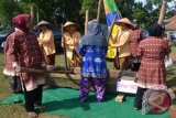 Sejumlah wanita desa sedang memperagakan musik lesung (alat menumbuk padi tradisional terbuat dari kayu) untuk mendukung kegiatan Siskamling/Kamtibmas, di Kecamatan Pringsewu, Kabupaten Pringsewu, Provinsi Lampung. (ANTARA FOTO/M.Tohamaksun/Dok).