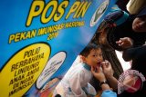 Petugas Kesehatan meneteskan vaksin polio pada seorang balita pada Pekan Imunisasi Nasional 2016 di Pos PIN kawasan Sawangan, Depok, Jawa Barat, Selasa (8/3). Pekan Imunisasi Nasional 2016 digelar serentak di seluruh Indonesia pada 8-15 Maret 2016 sebagai upaya mencegah penyebaran virus polio.ANTARA FOTO/Teresia May/ama/16