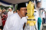 Asisten Bidang Ekonomi Pembangunan Pemprov Lampung,Drs Adeham mewakili Gubernur Lampung M.Ridho Ficardo ketika mengamati gerhana Matahari melalui teropong usai shalat gerhana, di lapangan Korpri Kantor Gubernur Lampung, Rabu (09/03/16). (ANTARA FOTO/Humas Pemprov Lampung). 