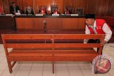 Kepala Desa Selo Awar-Awar Lumajang, Hariyono menggeser tempat duduk di ruang sidang di Pengadilan Negeri (PN) Surabaya, Jawa Timur, Kamis (10/3). Sidang kasus dugaan pembunuhan aktivis lingkungan Salim Kancil dengan terdakwa Kepala Desa Selo Awar-Awar Lumajang Hariyono tersebut ditunda. Antara Jatim/Didik Suhartono/zk/16