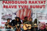 Anggota koalisi masyarakat sipil untuk penyelamatan TVRI Sumut menyanyikan lagu ketika melakukan aksi kepedulian, di Medan, Sumatera Utara, Selasa (15/3). Aksi itu mendesak pihak pengembang bertanggung jawab atas pembangunan gedung di dekat Stasiun TVRI Sumut yang berakibat terganggunya siaran tv tersebut. ANTARA SUMUT/Irsan Mulyadi/16