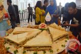 Sejumlah orang mengamati Big Sandwich Pecel berukuran pancang 60 centimeter, tinggi 40 centimeter dan luas 1.200 centimeter persegi sebelum dibagikan gratis kepada para tamu di salah satu hotel ternama di Kota Madiun Jawa Timur, Jumat (18/3). Inovasi kuliner perpaduan menu modern dengan menu khas daerah yang dilakukan hotel tersebut untuk memberikan sensasi sekaligus mengangkat citra makanan khas pecel Madiun. Antara Jatim/Foto/Siswowidodo/zk/16


