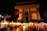 Warga menyalakan lilin bertuliskan angka 60 menjelang dimatikannya seluruh lampu listrik di monumen Simpang Lima Gumul, Kabupaten Kediri, Jawa Timur, Sabtu (19/3). Kegiatan mematikan lampu listrik dan mengganti dengan nyala lilin selama enam puluh menit tersebut sebagai kampanye penghematan energi guna menghindari pemanasan global. Antara Jatim/Prasetia Fauzani/zk/16