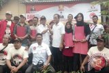 Salam Komando antara Inovator KGN Baldatun Center Sukabumi, Ade Dasep Zainal Abidin, bersama Kepala Desa Caringin Kulon, Alamsyah sekaligus foto bersama dengan para penerima bantuan usaha Warung Garudayaksa di Desa Caringin Kulon, Kecamatan Caringin, Kabupaten Sukabumi, Jawa Barat.  (Foto Antara/Aditya A Rohman).