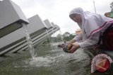 Sekar, siswi SDIT At-Taqwa mengisi kendi di air mancur Taman Pelangi Surabaya, Senin (21/3). Untuk memperingati Hari Air Sedunia tahun 2016, belasan siswa SDIT At-Taqwa Surabaya menghias kendi dan mengisi kendi dari air mancur Taman Pelangi sebagai simbol harapan untuk Surabaya menjadi Kota 1.000 Air Mancur. Antara Jatim/Hesty Putri Utami/EMY/16
