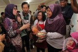 Anggota Komisi VIII DPR Desy Ratnasari (kiri)  mencicipi kripik saat kunjungannya di eks Lokalisasi Dolly, Surabaya, Jawa Timur, Senin (21/3). Kunjungannya bersama rombongan anggota Komisi VIII DPR lainnya tersebut untuk melihat secara langsung produk-produk yang dihasilkan UMKM warga setempat. Antara Jatim/Didik Suhartono/zk/16