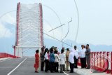 Presiden Joko Widodo (kedua kanan) meninjau Jembatan Pakkasih usai diresmikan di Kecamatan Tayan, Kabupaten Sanggau, Kalbar, Selasa (22/3). Presiden Joko Widodo menyatakan bahwa Jembatan Pakkasih sepanjang 1.420 meter yang menghubungkan Kalimantan Barat dengan Kalimantan Tengah tersebut, merupakan perwujudan dari misi penyebaran pembangunan infrastruktur yang merata di seluruh Indonesia. ANTARA FOTO/Jessica Helena Wuysang/wdy/16.