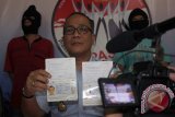 Kepala Kantor Imigrasi Klas II Blitar Tato Juliadin Hidayawan (tengah) menunjukkan paspor milik dua Warga Negara Asing (WNA) asal Taiwan dalam rilis di Press Room Kantor Imigrasi Blitar, Jawa Timur, Rabu (23/3). Petugas pengawasan dan penindakan keimigrasian (Wasdakim) Imigrasi Blitar berhasil mengamankan dua WNA asal Taiwan yakni Chen Kuo Kuang dan Chou Yu Hasien karena keduanya kedapatan menyalahi aturan izin tinggal serta melebihi masa izin tinggalnya di indonesia. Antara Jatim/Irfan Anshori/zk/16