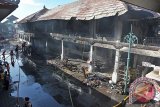 Petugas pemadam kebakaran berusaha menjangkau los pasar yang masih terbakar saat terjadi kebakaran di Pasar Seni Ubud, Bali, Kamis (24/3). Kebakaran pasar kerajinan di kawasan wisata tersebut terjadi sekitar pukul 05.00 Wita mengakibatkan puluhan kios hangus dan belum diketahui penyebabnya. ANTARA FOTO/Nyoman Budhiana/i018/2016.