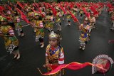 Sejumlah pelajar memperagakan tari Umbul-umbul Panji Gumilang secara kolosal di area monumen Simpang Lima Gumul, Kabupaten Kediri, Jawa Timur, Kamis (24/3). Acara yang melibatkan 1.212 pelajar sekolah dasar tersebut sebagai peringatan hari jadi Kabupaten Kediri ke-1.212 sekaligus mengkampanyekan ke dunia luar bahwa Kediri merupakan Bumi Panji. Antara Jatim/Prasetia Fauzani/zk/16